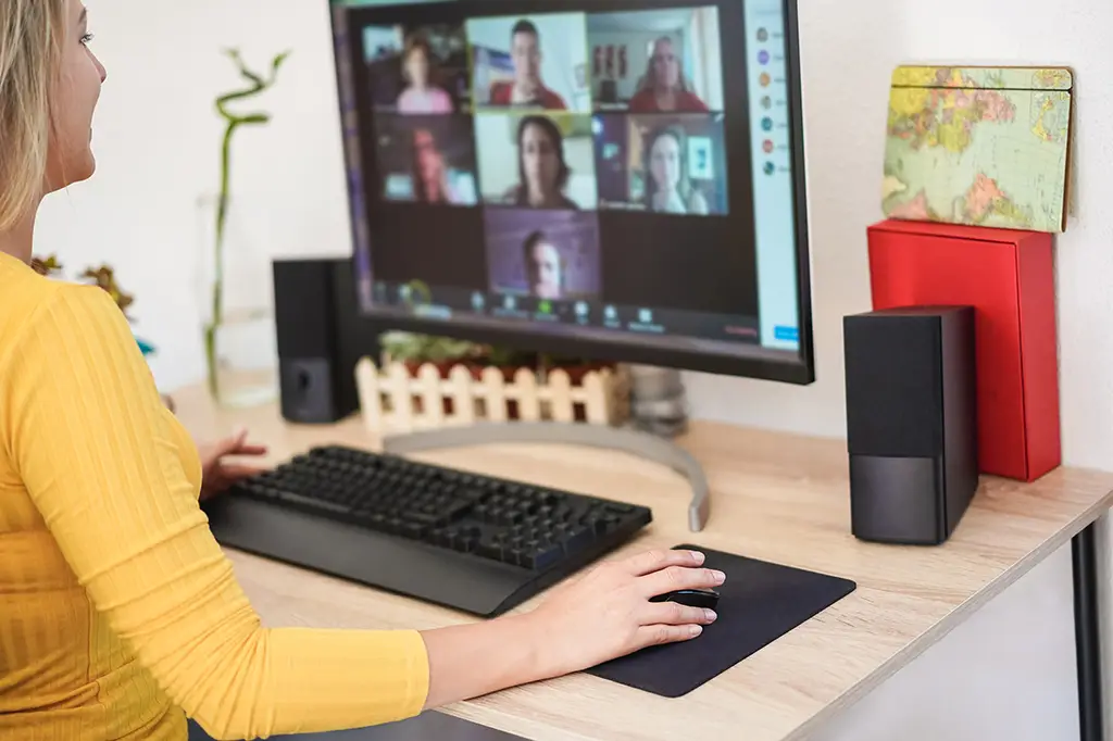 Young woman having a virtual meeting in video call with her team - Focus on right hand